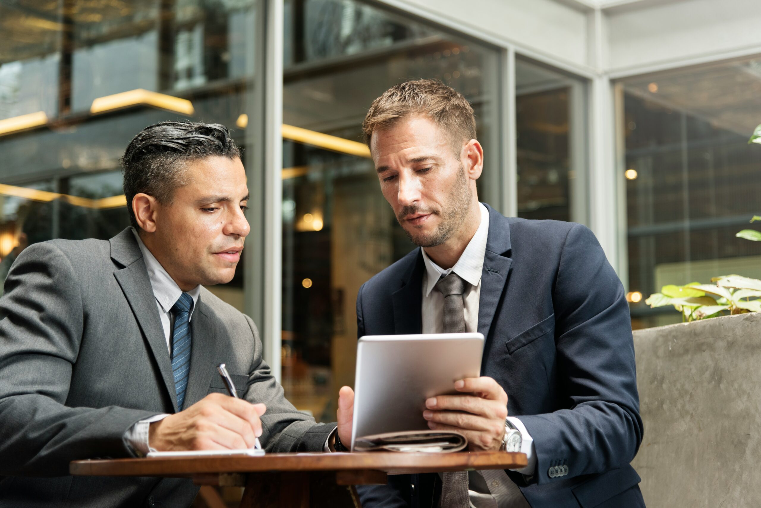 Chargé d'affaires professionnels en rendez-vous avec un dirigeant d'entreprise pour étudier un projet de financement.